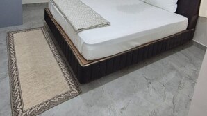 Un dormitorio con cama, ventilador de techo, aire acondicionado y ventana con cortinas.