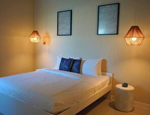 Ein Hotelzimmer mit einem Bett, zwei Wandleuchten und zwei gerahmten Bildern.