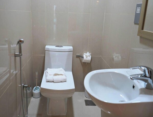 A bathroom with a toilet, bidet, and sink. - Spacious 2BR with Direct Beach Access in Al Reem (Abu Dhabi)