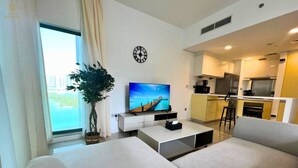 Una sala de estar moderna con un sofá, un televisor y una planta.