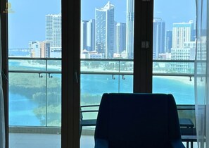 A room with a view of a city skyline and a body of water. - Beachfront 2BR Escape in Al Reem (Abu Dhabi)