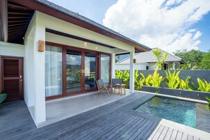 Una casa moderna con piscina, terraza de madera y mobiliario exterior.