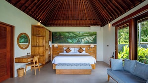 A bedroom with a wooden ceiling, a large bed, a desk, and a sofa. - Gauri Villas Sidemen (Sidemen)