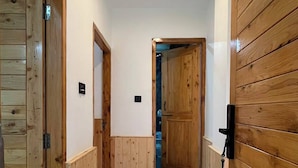 A hallway with wooden doors and a tiled floor. - Hotel The Travica Kasol (Kasol)