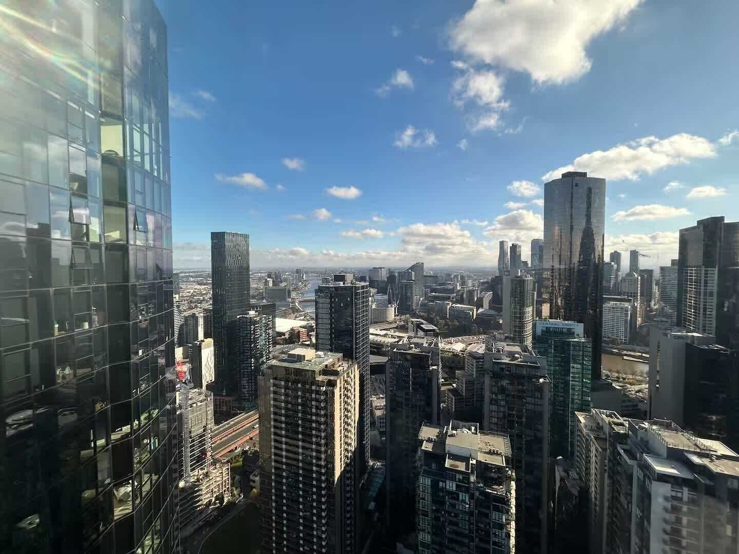 Une vue urbaine avec de hauts immeubles, une rivière et un ciel dégagé.