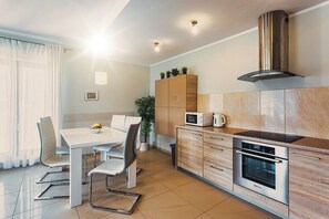 Eine moderne Küche mit Essbereich, Edelstahlgeräten und einem eingebauten Backofen.