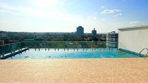 A rooftop pool with a cityscape view, a clear sky, and a distant building. - Marina Bay Square Westlands (Nairobi)