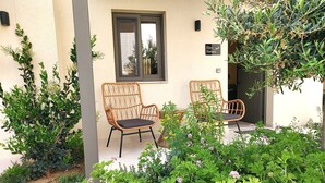 A building with two wicker chairs outside, a window, and a sign reading 'Elea Natura.' - Elea Suites Adelianos Kampos (Rethymno)