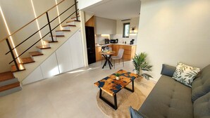 A modern living space with a staircase, a dining area, and a kitchen. - Elea Suites Adelianos Kampos (Rethymno)