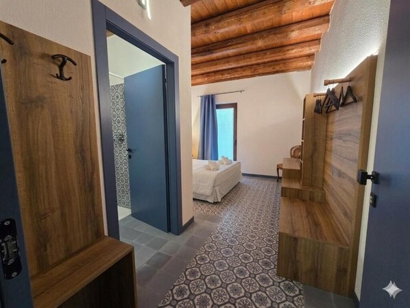 A bedroom with a bed, a wooden door, and a patterned floor.
