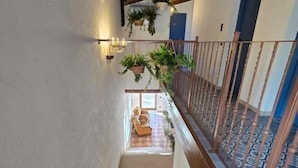 A staircase with wooden railings and a view of a room with a blue door.