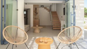 Ein modernes Interieur mit einer Treppe, offenen Raum und zwei Korbstühlen.