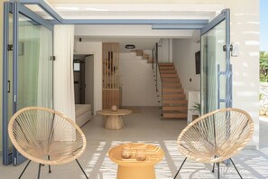 Ein modernes Interieur mit einer Treppe, offenen Raum und zwei Korbstühlen.