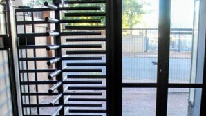 A room with a tiled floor, a metal rack with multiple hooks, and a glass door leading outside. - Beautiful City Centred Penthouse (Bloemfontein)