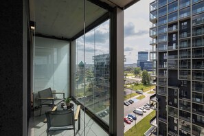 Ein Balkon mit Blick auf einen Parkplatz und umliegende Gebäude.