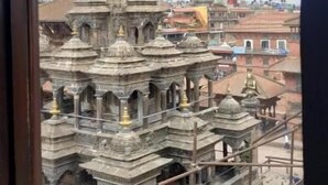 Un temple doté d’une grande flèche centrale et de plusieurs structures plus petites, vu à travers une fenêtre.