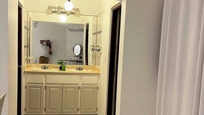 A bathroom with a sink, mirror, and cabinets. - The Distrito Atelier (Santo Domingo)