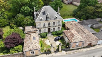 Una extensa propietat amb una casa principal, una piscina i diversos edificis més petits.