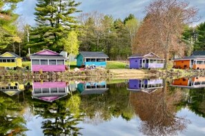 A row of colorful houses by a calm lake with reflections. - Lakefront Cottage for a Romantic Weekend Getaway near Manchester, New Hampshire (Northwood)
