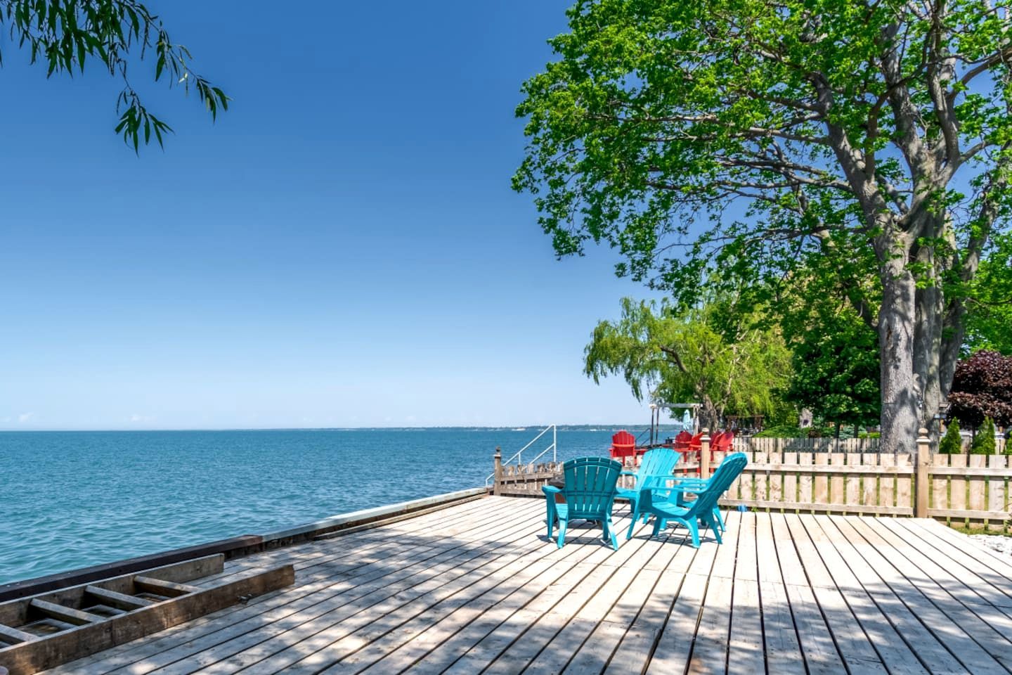 Terraza de madera con sillas y vista al mar.