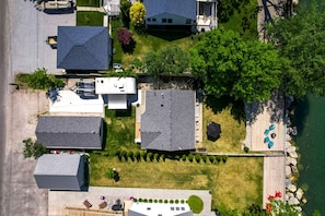 An aerial view of a residential area with houses, a dock, and a small boat. - Stunning Cottage with Nice Views and Fire Pit in Leamington, Ontario (Leamington)