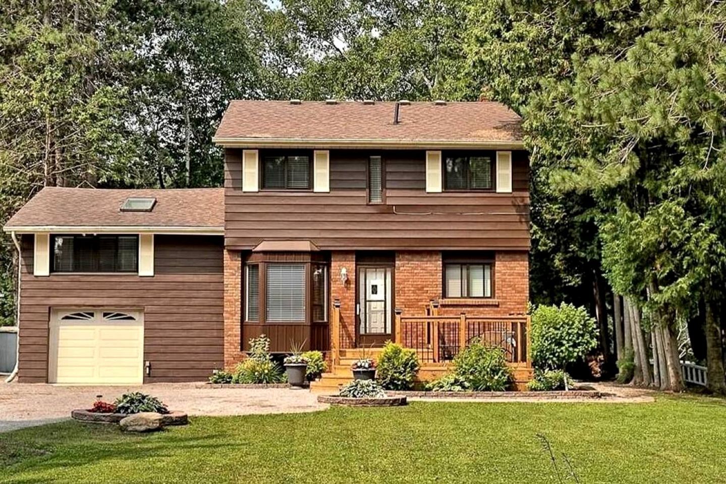 A two-story house with a garage, a front porch, and a small front yard with landscaping.