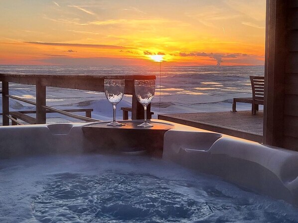A hot tub with two glasses on a wooden deck overlooking a sunset over the ocean. - Coast Rental with Hot-Tub and Equipped Deck in Ontario (Leamington)