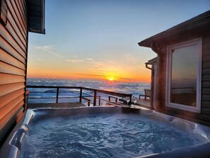 A hot tub with a sunset view, wooden deck, and a bench. - Coast Rental with Hot-Tub and Equipped Deck in Ontario (Leamington)