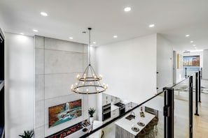 Une cuisine moderne dotée d’un îlot central, d’un éclairage encastré au plafond et d’un luminaire suspendu.