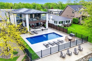 Una casa moderna amb piscina, mobiliari exterior i pati tancat.