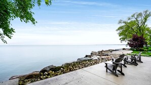 A waterfront patio with outdoor seating and a view of the water. - Sophisticated Shoreline Retreat with Sunset Patio & Poolside Lounging in Ontario, Canada (Leamington)