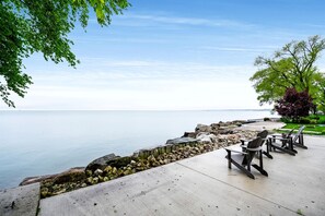 A waterfront patio with outdoor seating and a view of the water. - Sophisticated Shoreline Retreat with Sunset Patio & Poolside Lounging in Ontario, Canada (Leamington)