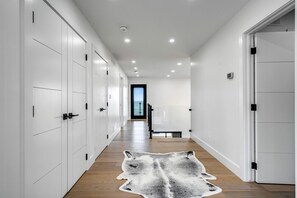 Un passadís amb portes blanques, un sòl de fusta i una catifa de llana.