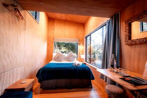 A wooden room with a bed, a desk, and a window. - Comfortable Cabin Rental for a Queenstown Holiday in New Zealand (Queenstown)