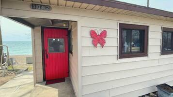 Un petit bâtiment avec une porte rouge, un motif de papillon et le numéro « 1092 » sur le toit.