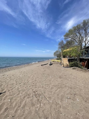 A beach with a wooden structure, a clear sky, and a calm sea.