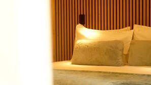 Un lit avec des oreillers et un mur composé de lattes de bois verticales.