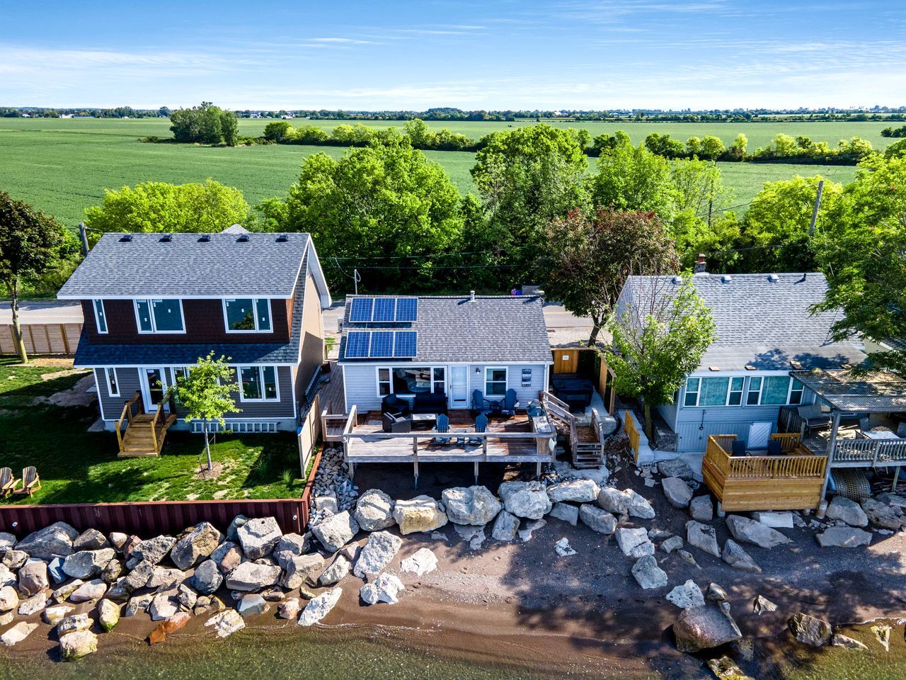 A residential area with multiple houses, a deck, and a rocky landscape.
