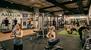 A gym with various exercise equipment, a treadmill, and people working out. - Amazon Hotel - Free Massage, Breakfast, & Dinner Included (Baku)