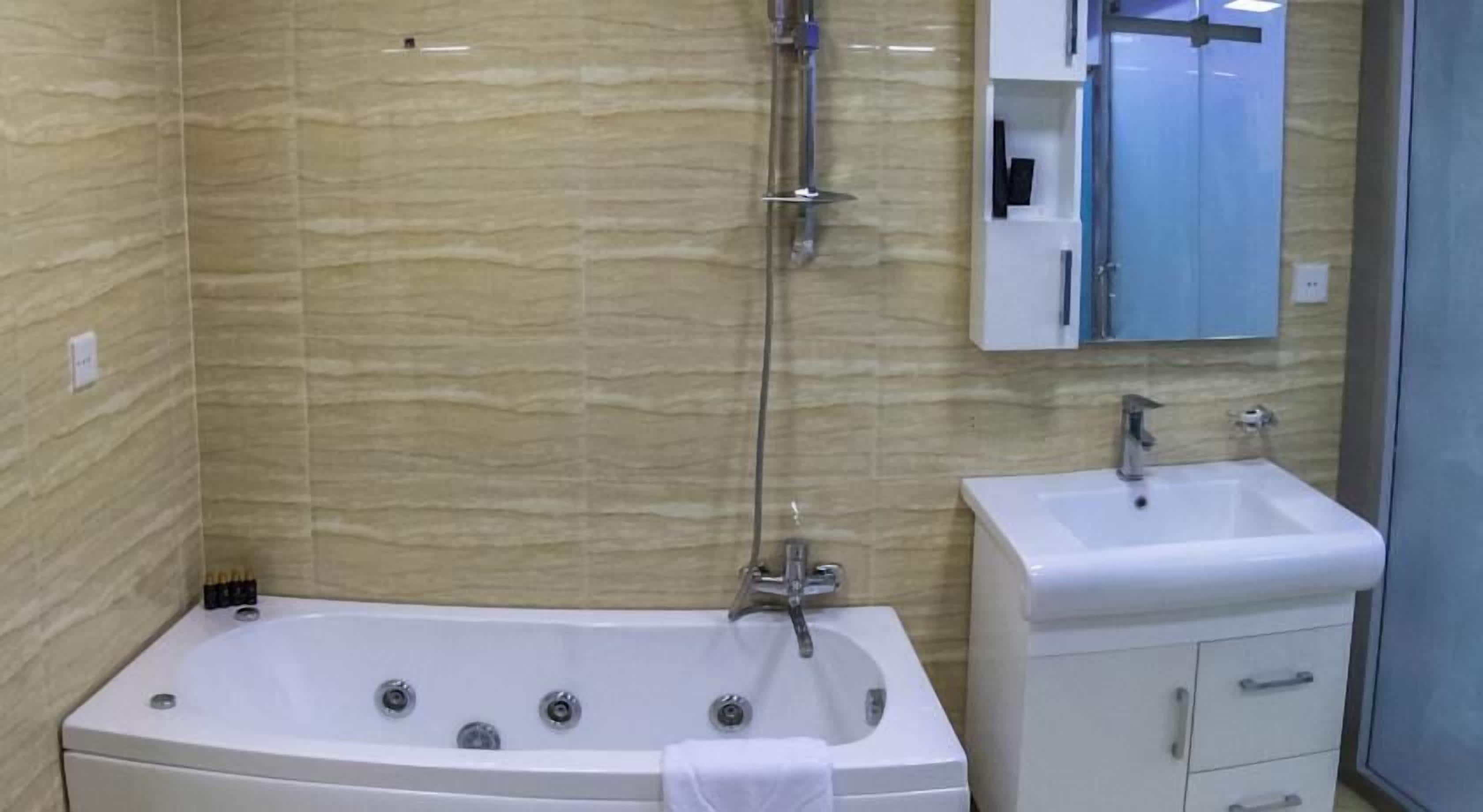 Une salle de bain avec une baignoire sur pieds, un lavabo et un miroir au-dessus du lavabo.