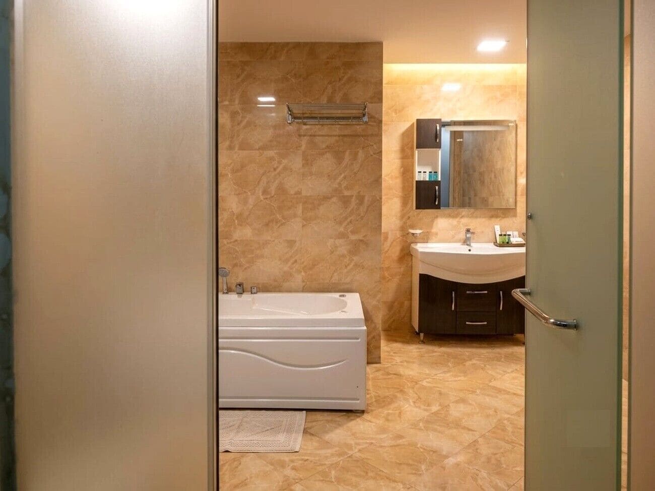 A modern bathroom with a bathtub, a sink, and a mirror.