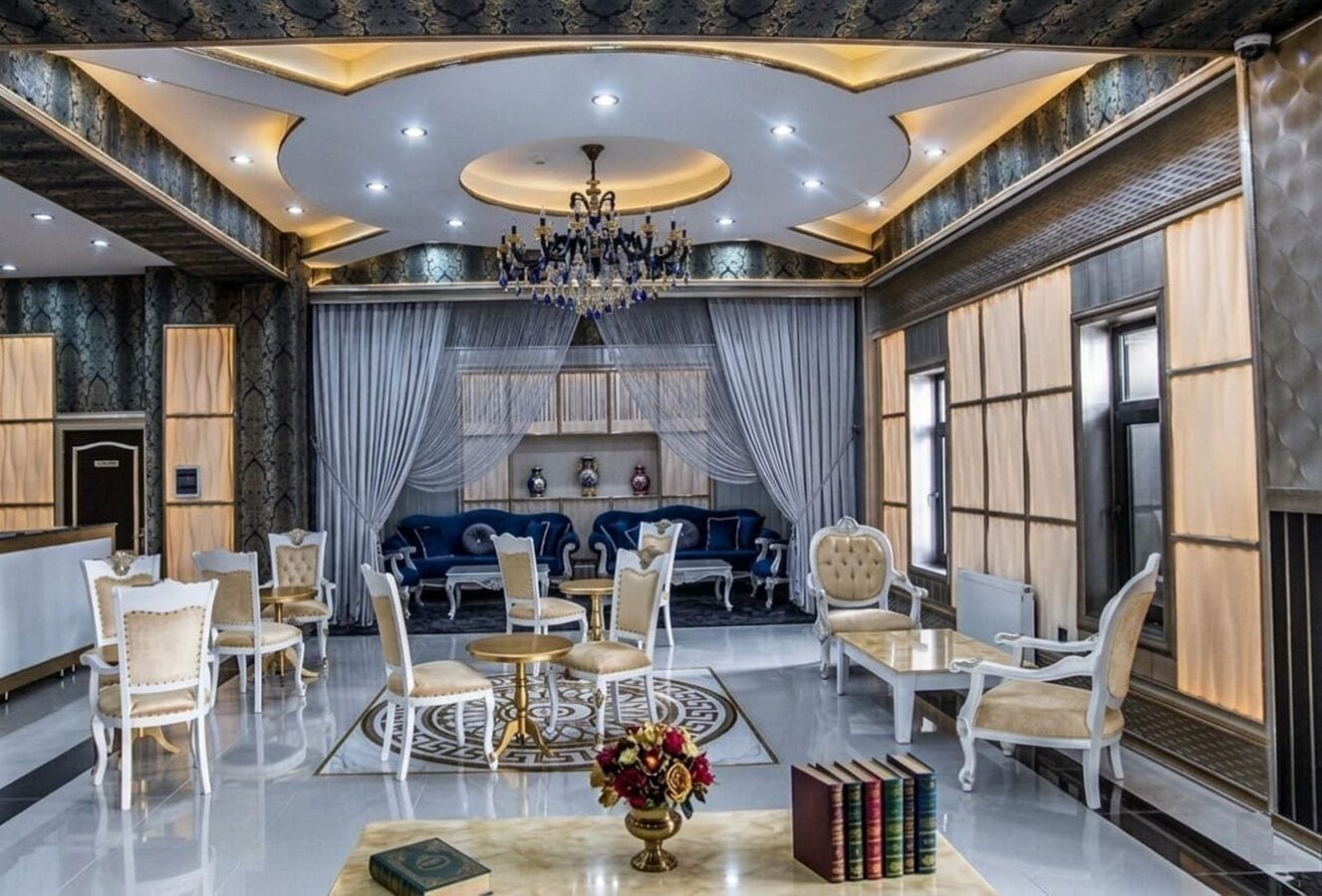 Un hall d’entrée luxueux agrémenté d’un lustre, d’un espace salon et d’un comptoir d’accueil.