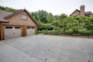 Un bâtiment à deux étages, doté d’un garage, d’une cheminée et d’une pelouse bien entretenue, agrémentée d’arbres et d’arbustes.