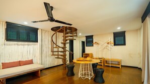 Uma sala de estar moderna com escada em espiral, móveis de madeira e um ventilador de teto.