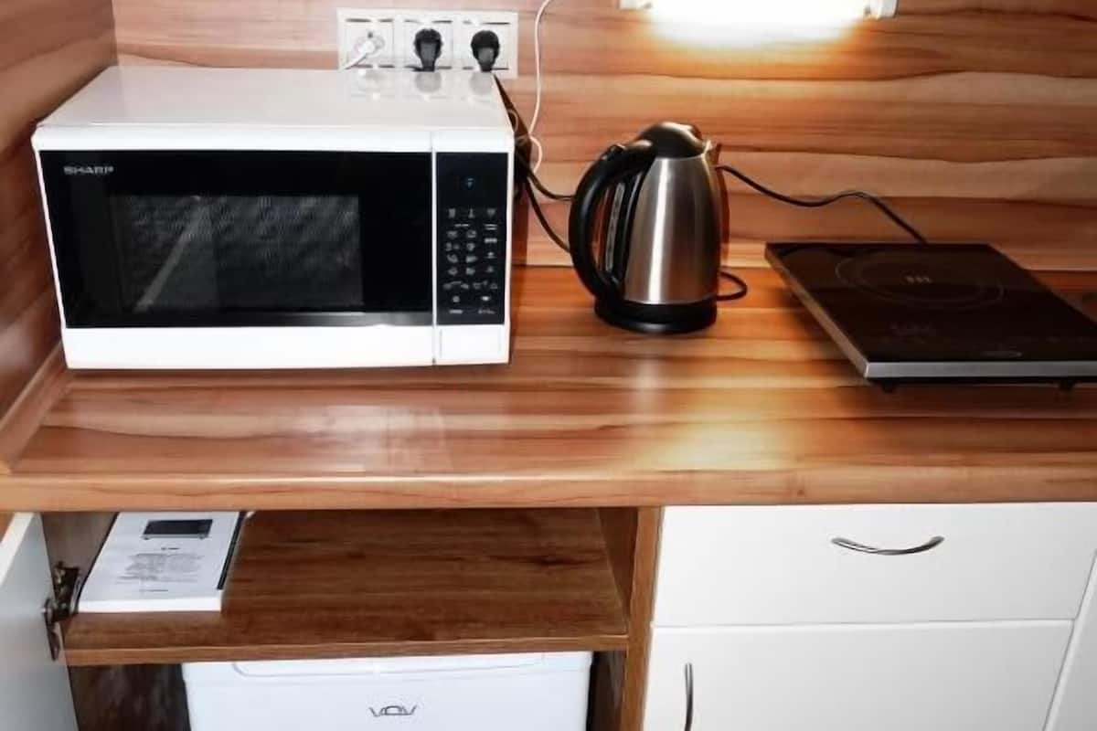 Une petite cuisine Ă©quipĂ©e dâun four Ă micro-ondes, dâune machine Ă cafĂ© et dâun petit rĂ©frigĂ©rateur.