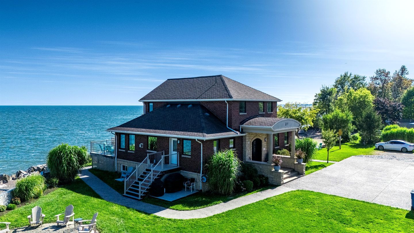 A two-story house with a balcony, a staircase, and a driveway.