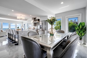 A modern kitchen with a dining area, large windows, and a view of the ocean. - Luxury Waterfront Estate with Beach Access and Expansive Grounds in Ontario, Canada (Wheatley)
