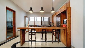 Una cocina con una isla de madera, taburetes de bar, luces colgantes y vistas al exterior.