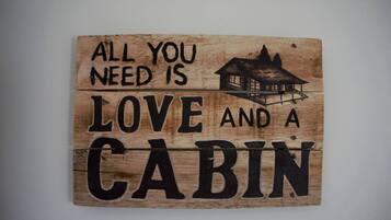 Ein Holzschild mit dem Schriftzug 'Alles was man braucht ist Liebe und eine Hütte'.