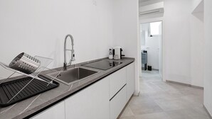 A modern kitchen with a sink, a kettle, and a coffee maker. - Apartment 'Nora' with Shared Garden, Wi-Fi and Air Conditioning (Polpenazze del Garda)